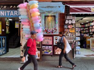 Personas caminan frente a comercios en un mercado de México