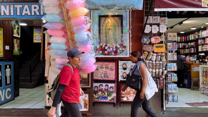 Personas caminan frente a comercios en un mercado de México
